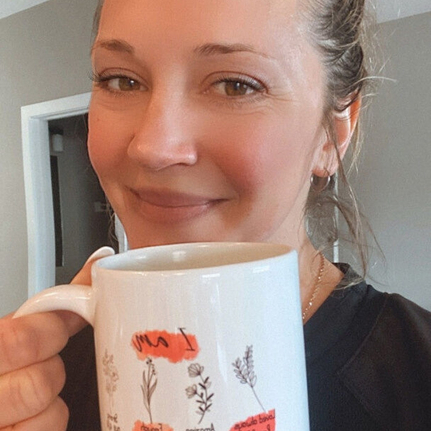 A Tease customer, smiling over her mug