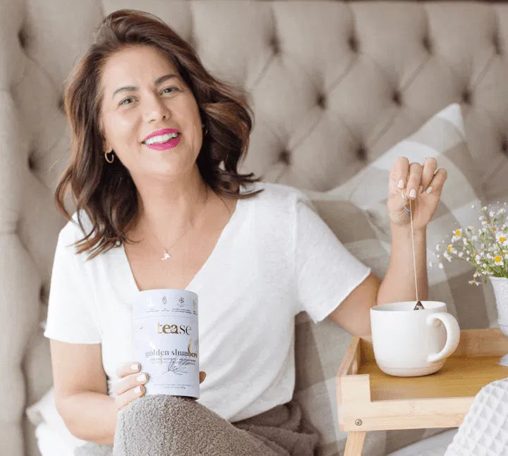 Woman preparing Golden Slumbers tea in bed as part of a calming self-care ritual