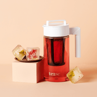 Tease Wellness Cold Brew Iced Tea & Coffee Maker Kit with clear pitcher, white lid, and red tea infusion surrounded by.